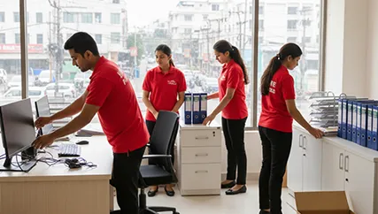 Office movers organizing desks and computers during office relocation in Dholera, Ahmedabad