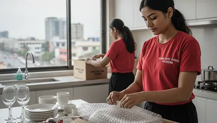 Mover packing kitchen items with care, ensuring they are properly secured for moving.