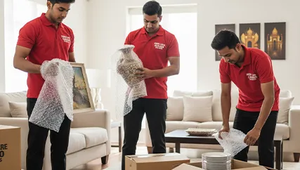 Professional movers carefully packing household items for a safe move