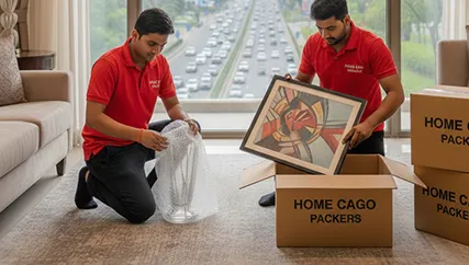 Movers wrapping fragile items for safe relocation along Dwarka Expressway