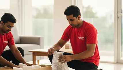 Mover carefully wrapping fragile items for relocation