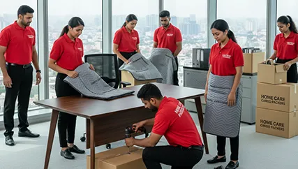 Office movers disassembling office furniture and packing electronics in Sector 103