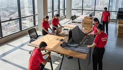 Office movers disassembling office furniture and packing electronics in Sector 105