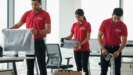 Office movers wrapping and packing equipment