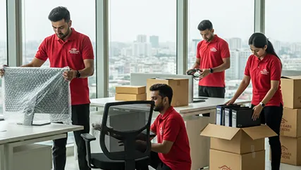 Professional movers handling office furniture and electronics with care