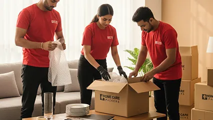 Movers carefully wrapping and packing fragile items into boxes for safe transport