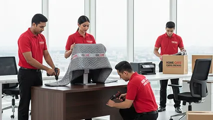 Office movers disassembling furniture and carefully packing electronics in Sector 70