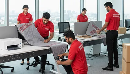 Office movers disassembling office furniture and packing electronics in Sector 75