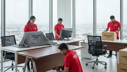 Office movers disassembling furniture and packing office electronics with care
