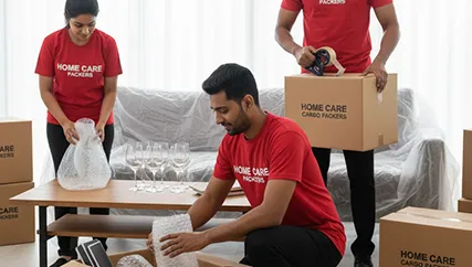 Movers wrapping fragile items and securing them for transport in Sector 91