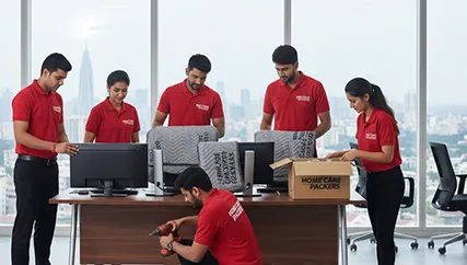 Office movers disassembling office furniture and packing electronics in Sector 96