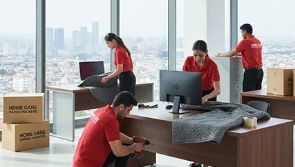 Office movers carefully disassembling office furniture and packing electronics