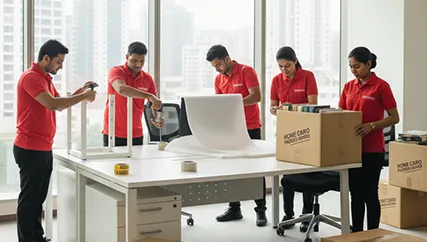 Office movers disassembling office furniture and packing electronics in Sector M 10