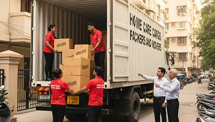 Movers carefully loading office furniture and electronics into a truck in Sector M 18