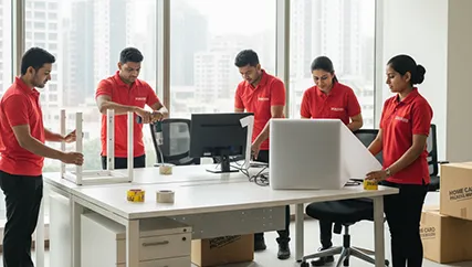 Office movers carefully disassembling office furniture and packing electronics in Sector M 7