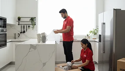 Movers wrapping fragile kitchenware in Sohna Sector 14, Gurugram