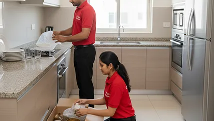 Movers wrapping fragile kitchen items in South City, Gurugram