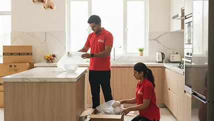 Movers wrapping fragile kitchenware and decor in Sushant Lok I, Gurugram