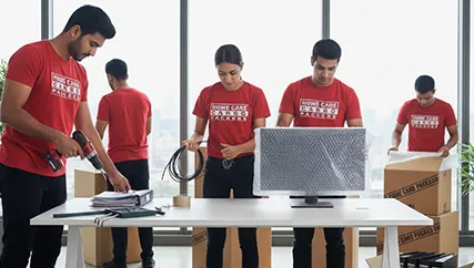 Movers shifting office desks and equipment with professional care