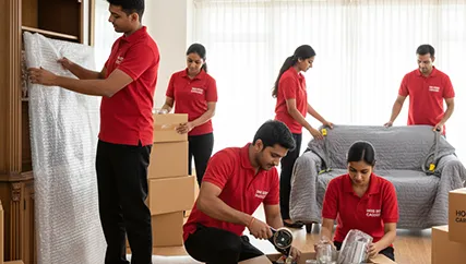 Household items being packed by professional movers in a spacious living room