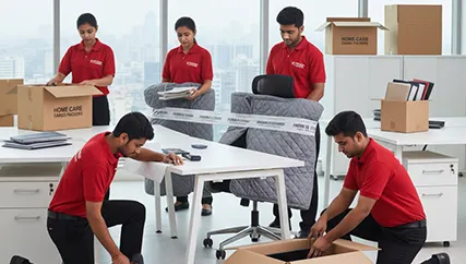 Office movers disassembling desks and packing computers in a corporate office space