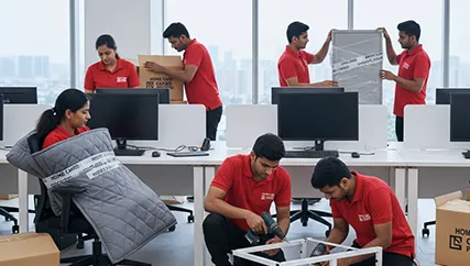 Movers organizing and packing office files, electronics, and furniture in an office space