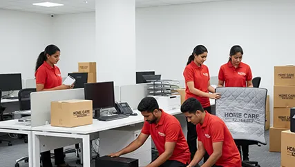 Office movers disassembling furniture and packing electronics in a corporate office space