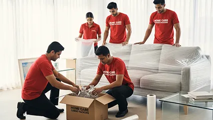 Movers carefully packing fragile furniture and artwork in a home in Muhana Mandi