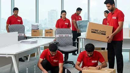 Movers disassembling office furniture and packing computers and files in an office