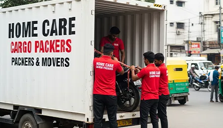 Home Care Cargo Packers team professionally loading a motorcycle into a transport vehicle for safe transit.