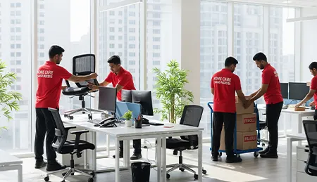 Movers unpacking office supplies, computers, and furniture inside a new office space